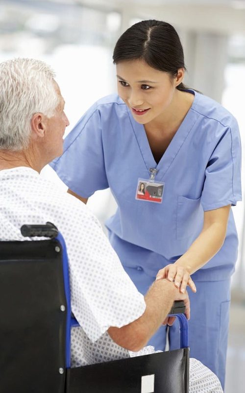 Senior patient sitting in wheelchair talking with young doctor